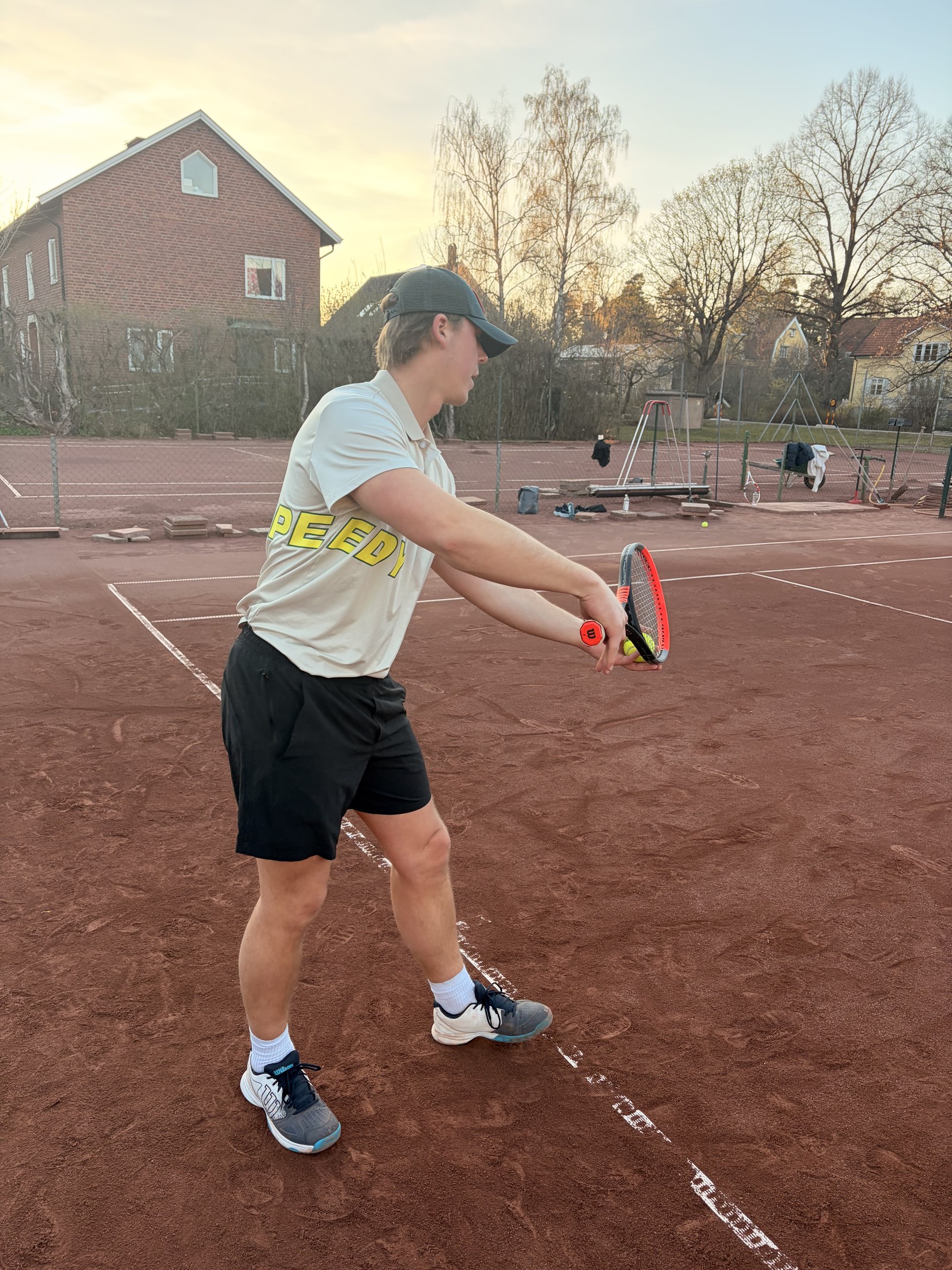 Athlete in the SPEEDY polo preparing a tennis shot on a clay court